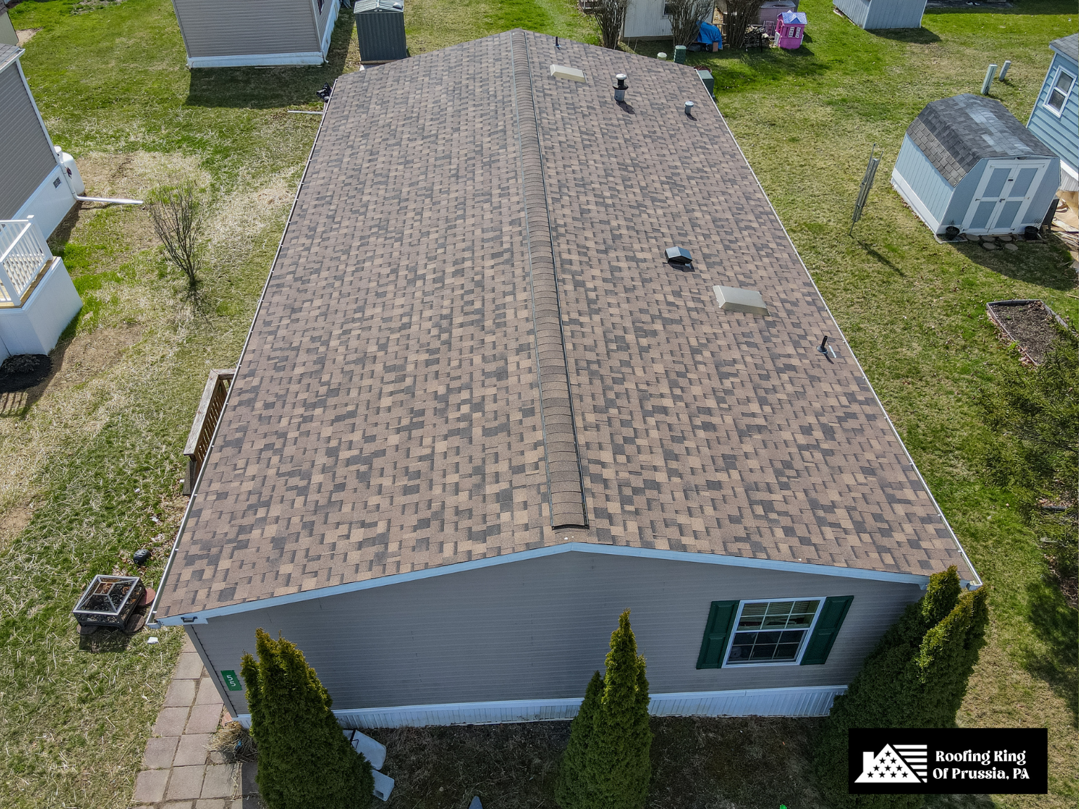 Single-story home with durable brown asphalt shingle roofing.